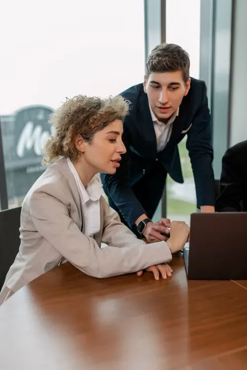 Deux consultants analysant un tableau de bord sur un ordinateur portable