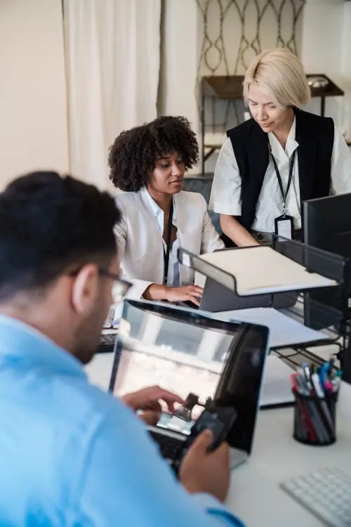 Équipe au travail dans un bureau, plusieurs postes équipés d’ordinateurs