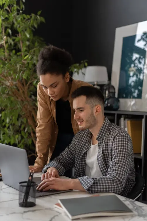 Formatrice accompagnant un collaborateur sur son poste de travail
